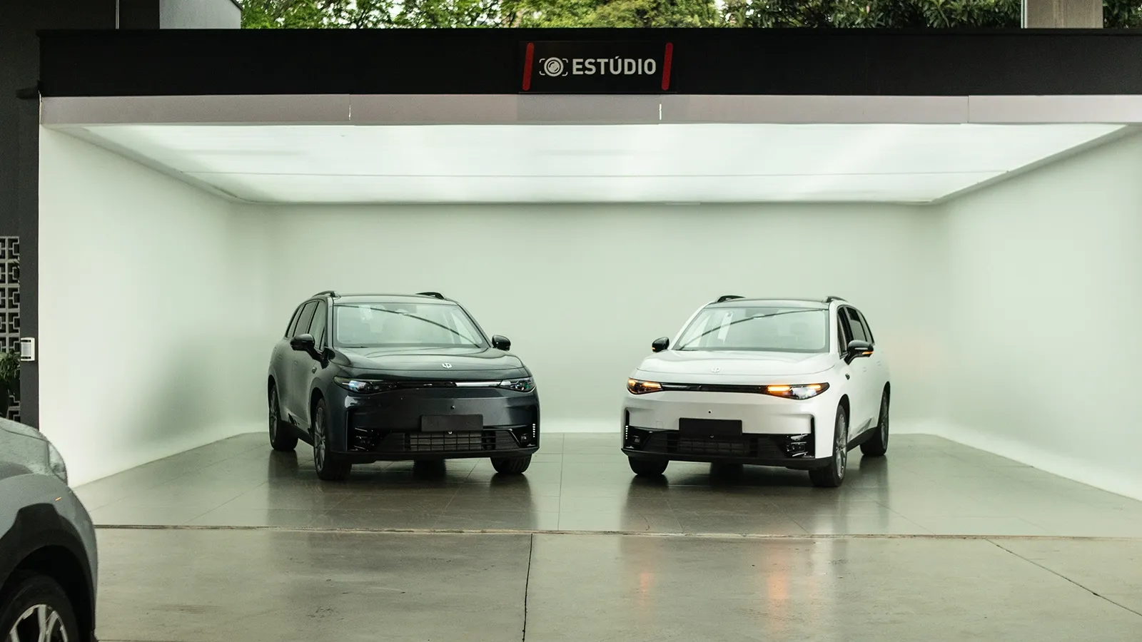Dois Leapmotor C10, um cinza e um branco, no estúdio da Kikoautos em Taubaté