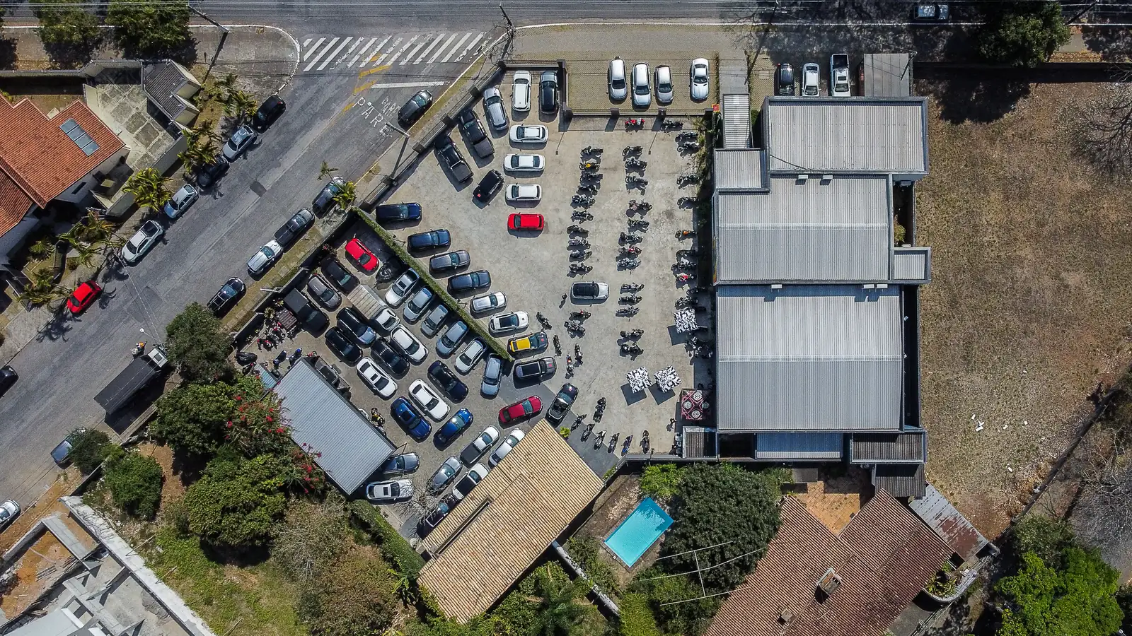 Vista aérea do pátio da Kikoautos, com dezenas de carros e motos enfileirados