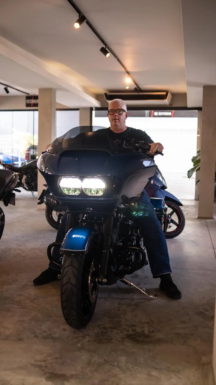 Motociclista numa Harley-Davidson Road Glide azul no estúdio da Kikoautos